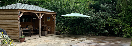 Woodern summer house positioned next to a patio